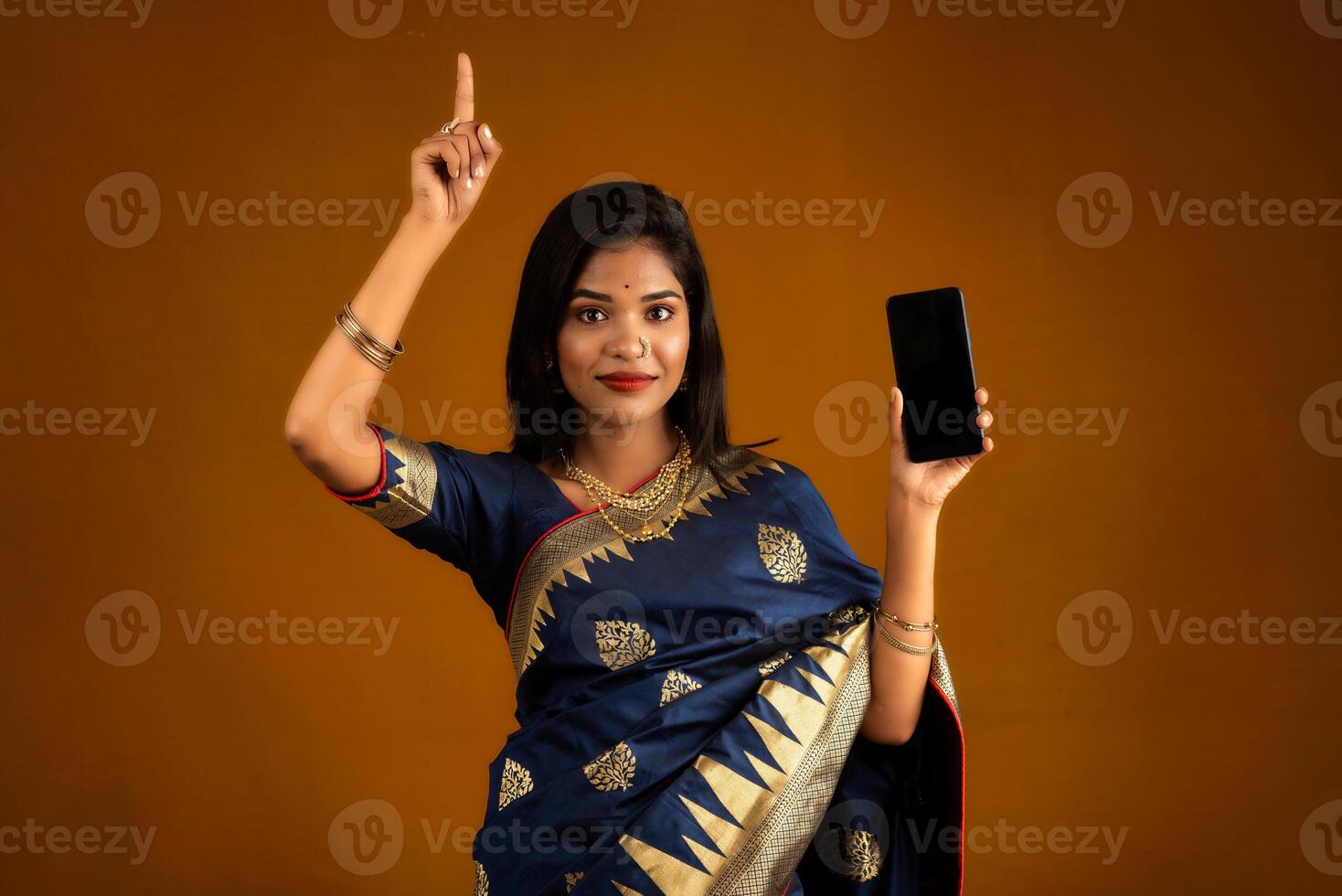 Young beautiful girl showing a blank screen of smartphone or mobile or tablet phone photo