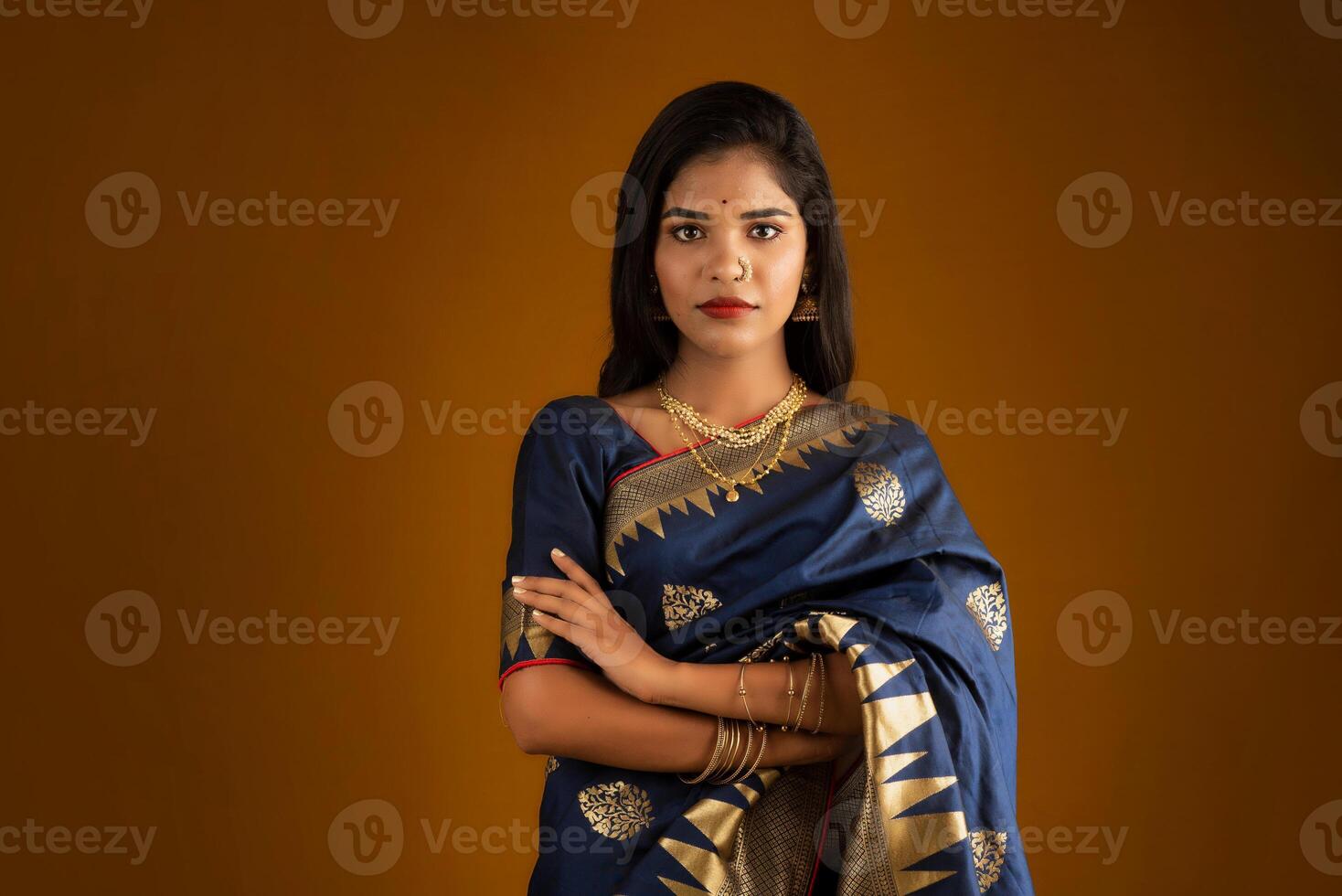 Portrait of a young girl or woman posing on brown background photo