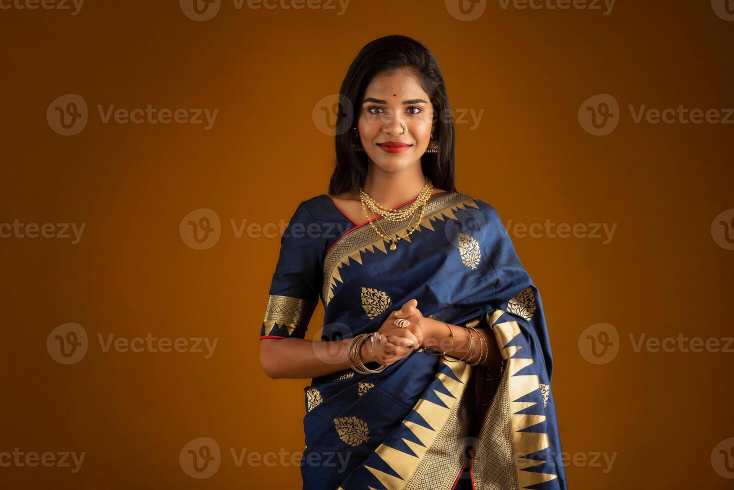 Portrait of a young girl or woman posing on brown background photo