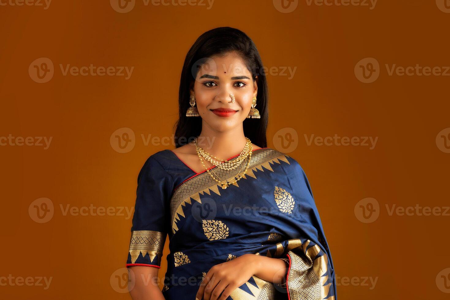 Portrait of a young girl or woman posing on brown background photo