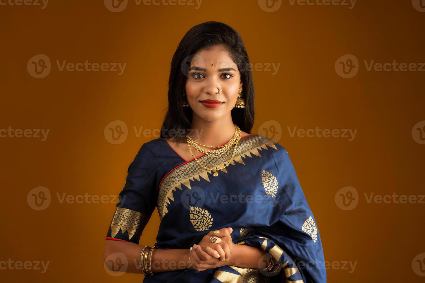 Portrait of a young girl or woman posing on brown background photo