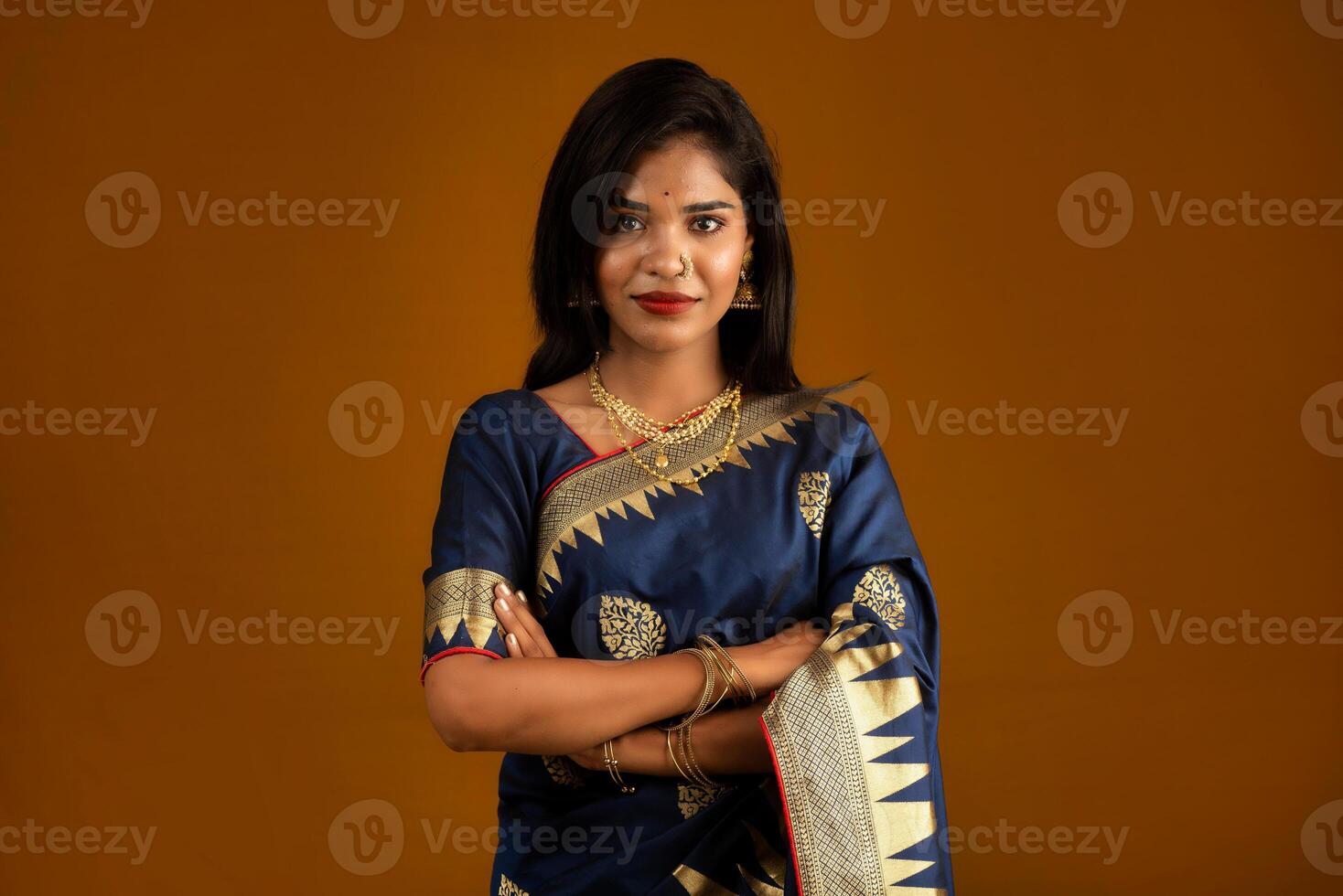 Portrait of a young girl or woman posing on brown background photo