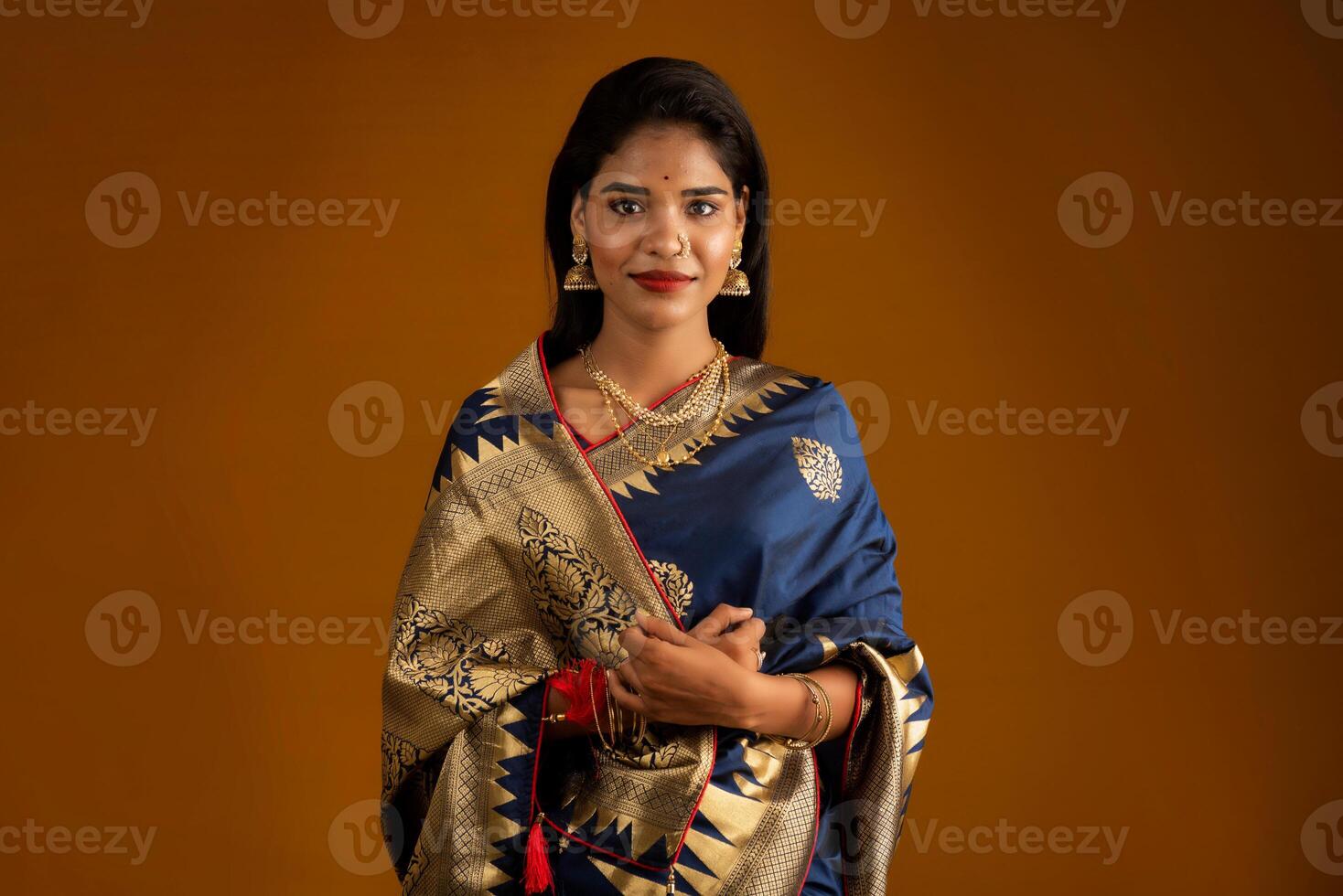 Portrait of a young girl or woman posing on brown background photo