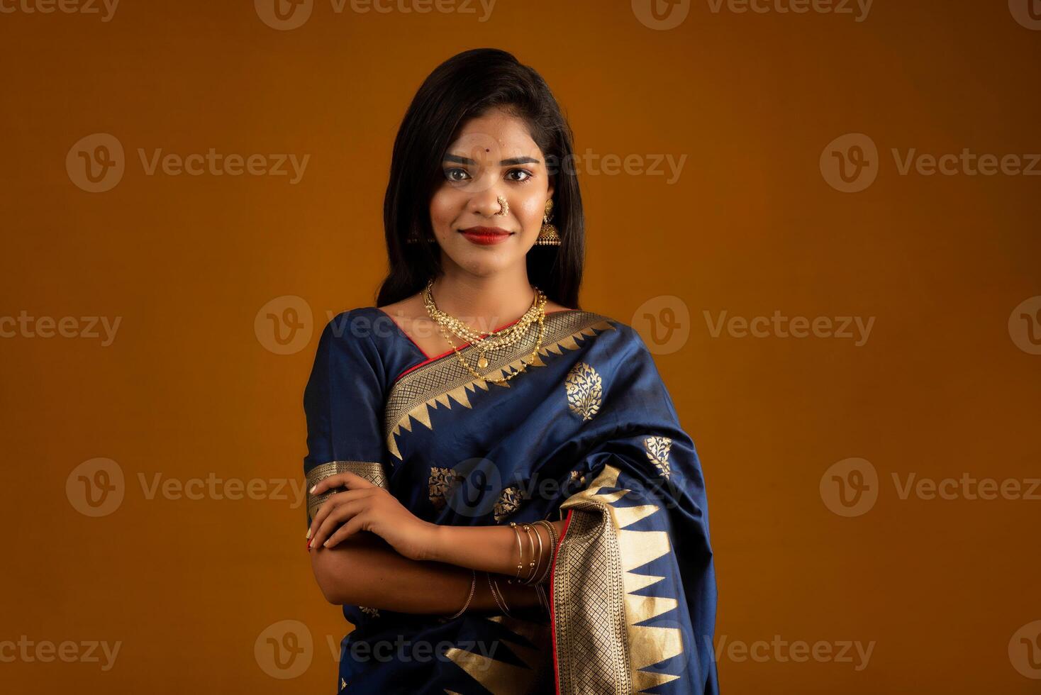 Portrait of a young girl or woman posing on brown background photo