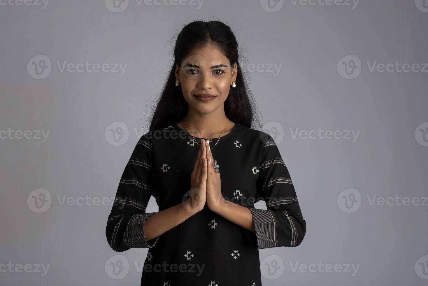 Beautiful Indian girl with welcome expression or inviting or greeting Namaste photo