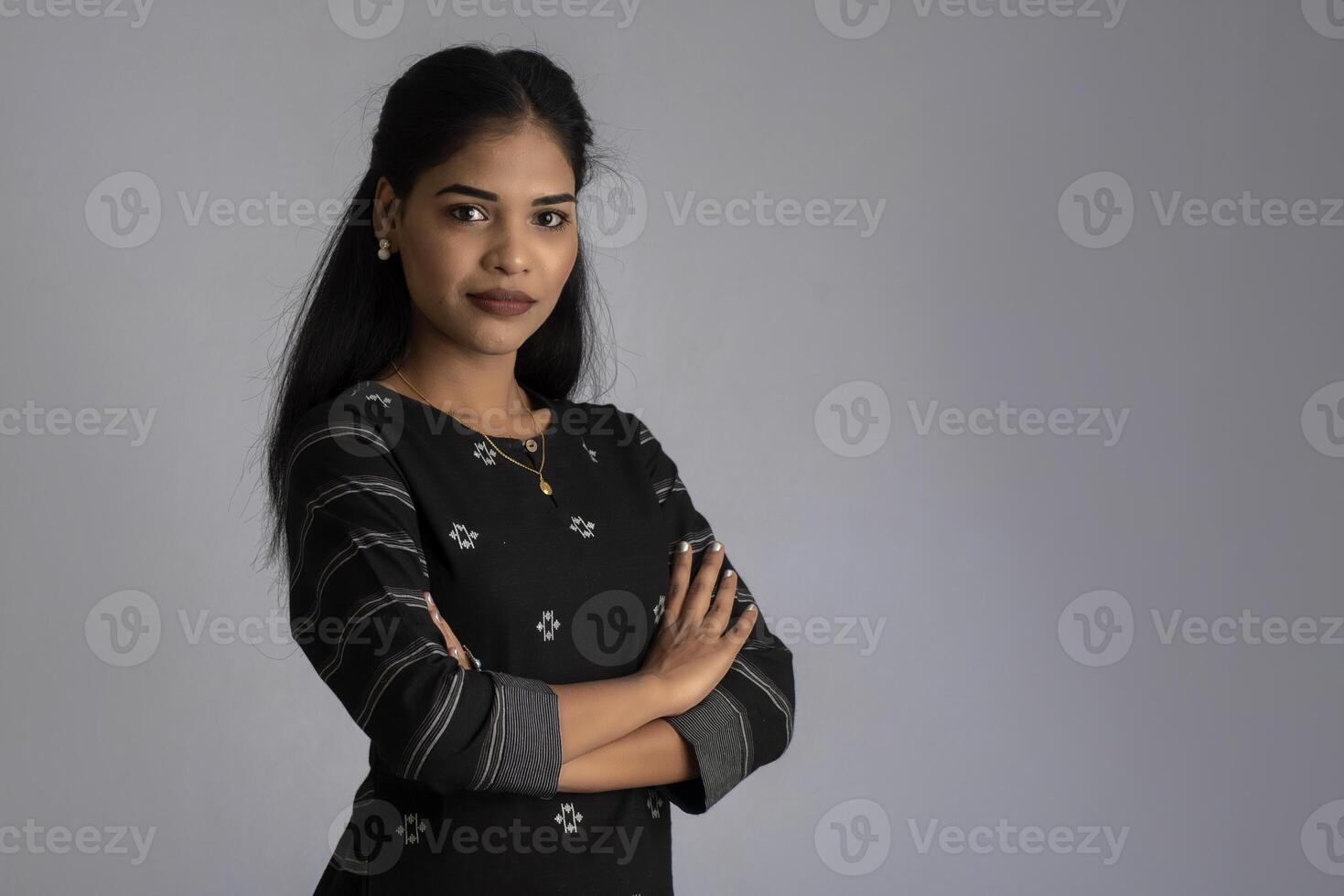 Portrait of a young beautiful cute cheerful girl smiling looking at the camera on gray background photo
