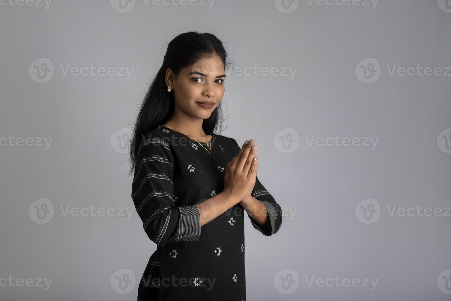 Beautiful Indian girl with welcome expression or inviting or greeting Namaste photo