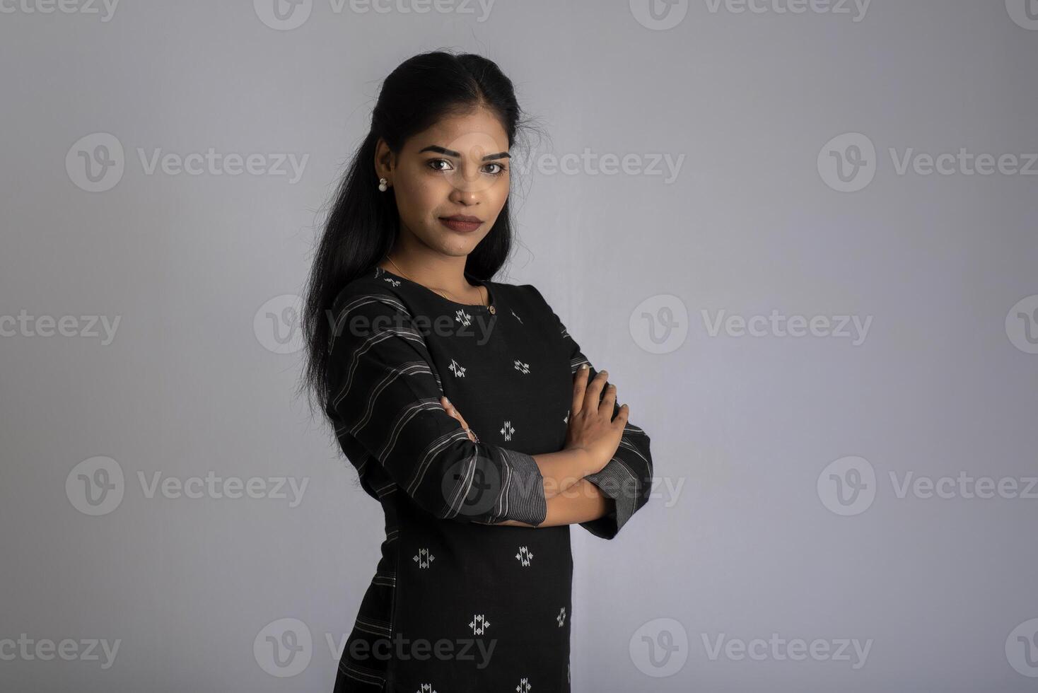 Portrait of a young beautiful cute cheerful girl smiling looking at the camera on gray background photo