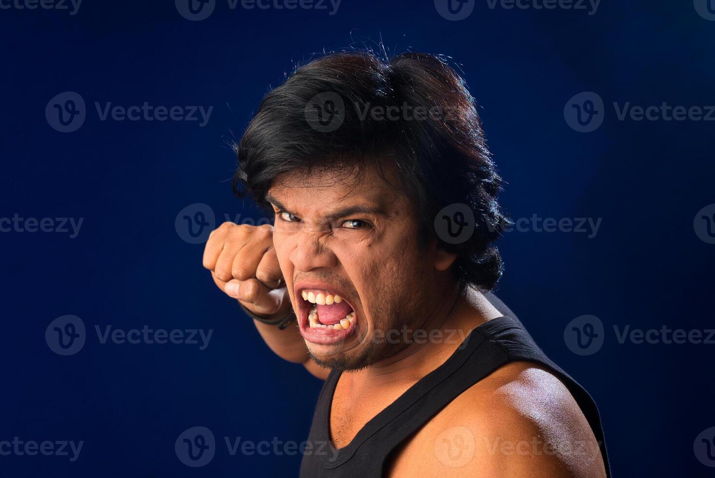 Portrait of a young man posing and showing his muscular body. The concept of a healthy lifestyle on blue background. photo