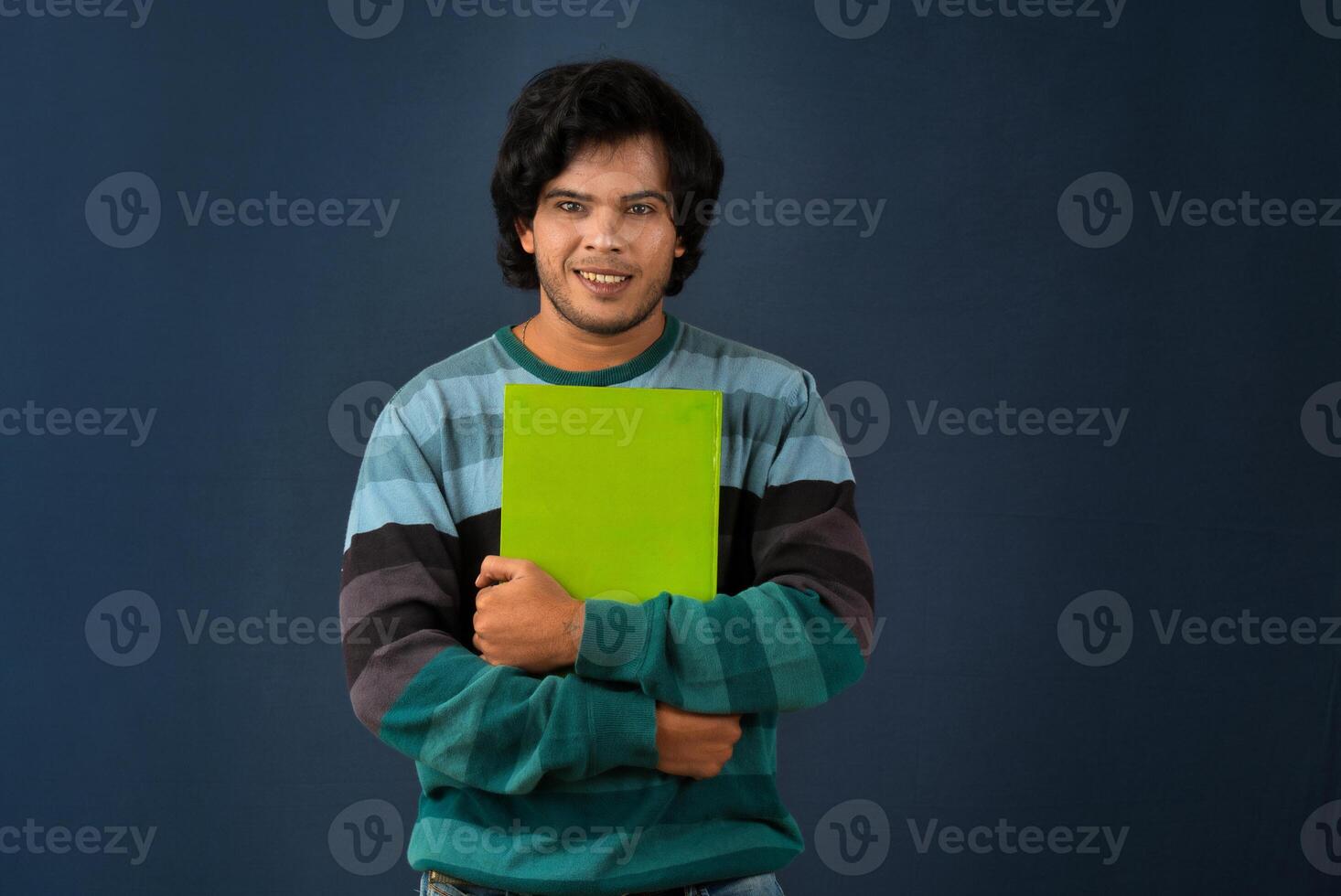 Young happy man holding and posing with the book on background. photo