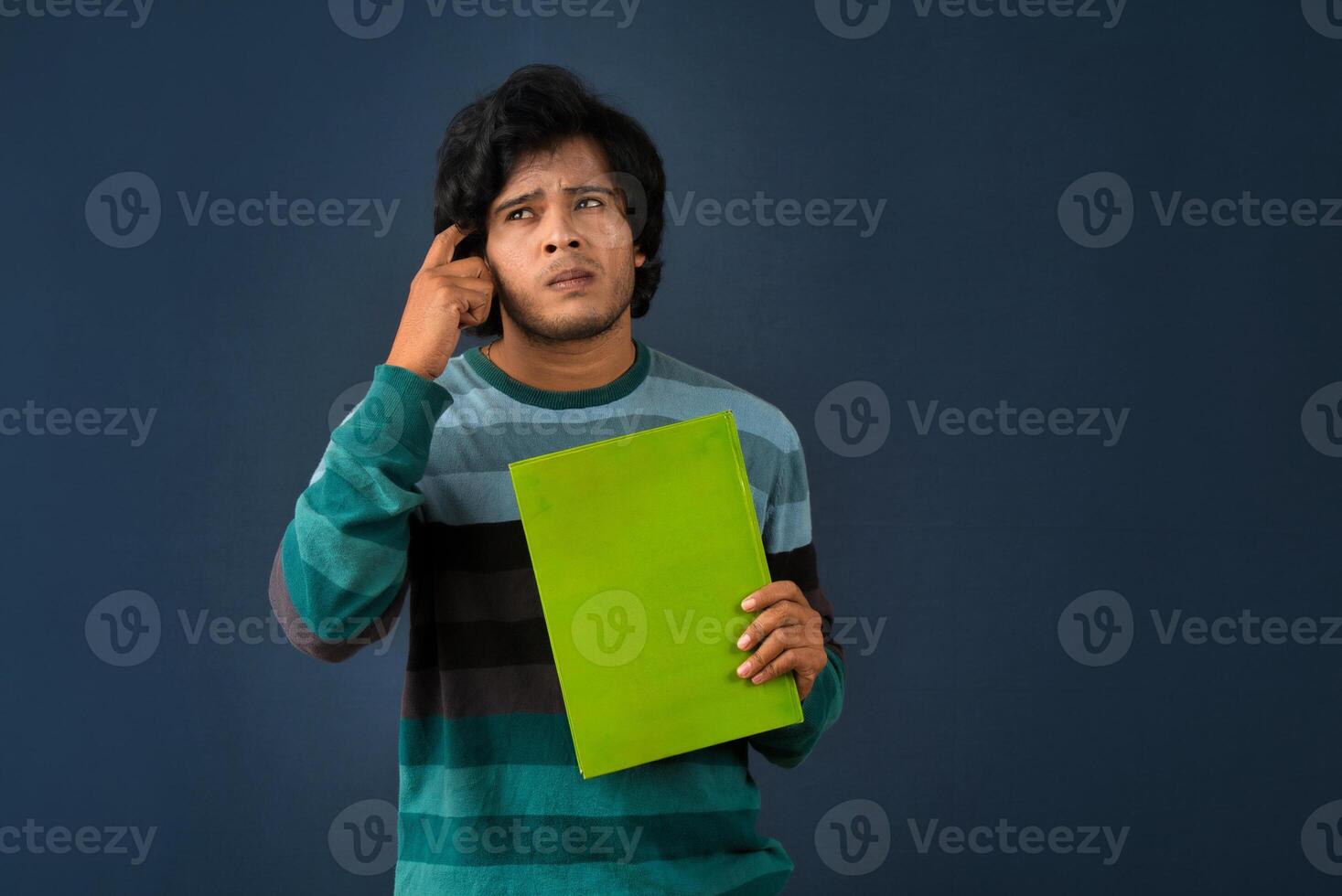 Young happy man holding and posing with the book on background. photo