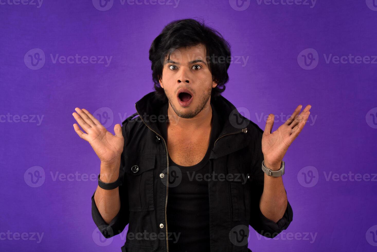 Young handsome man over dark background afraid and shocked with surprise and amazed expression, fear and excited face. photo