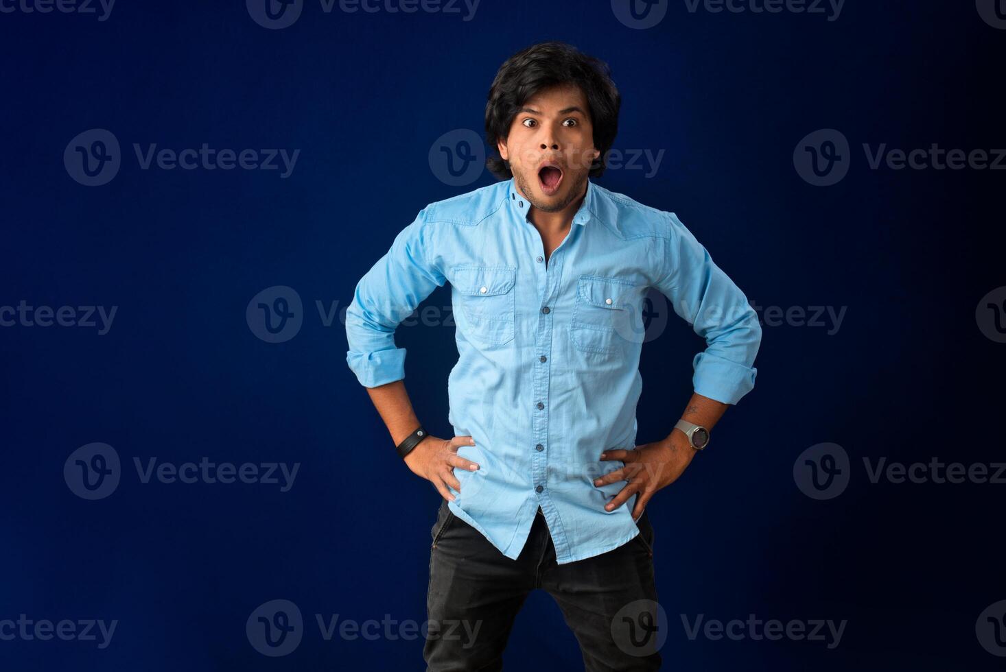 Young handsome man over dark background afraid and shocked with surprise and amazed expression, fear and excited face. photo