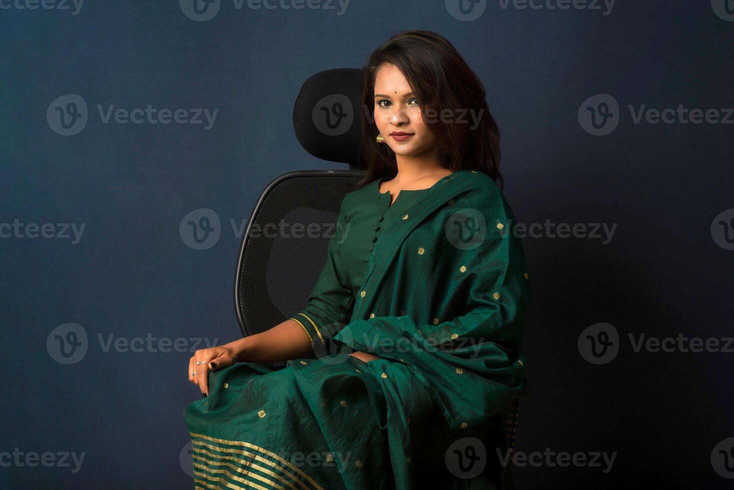 A beautiful girl sitting on an executive chair and posing. photo