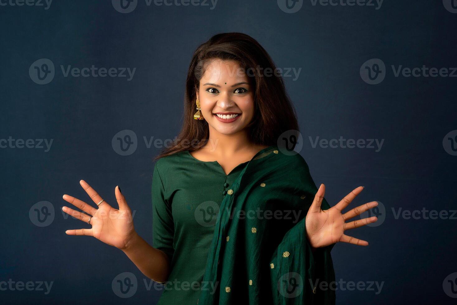 Young beautiful girl on gray background afraid and shocked with surprise and amazed expression, fear and excited face. photo