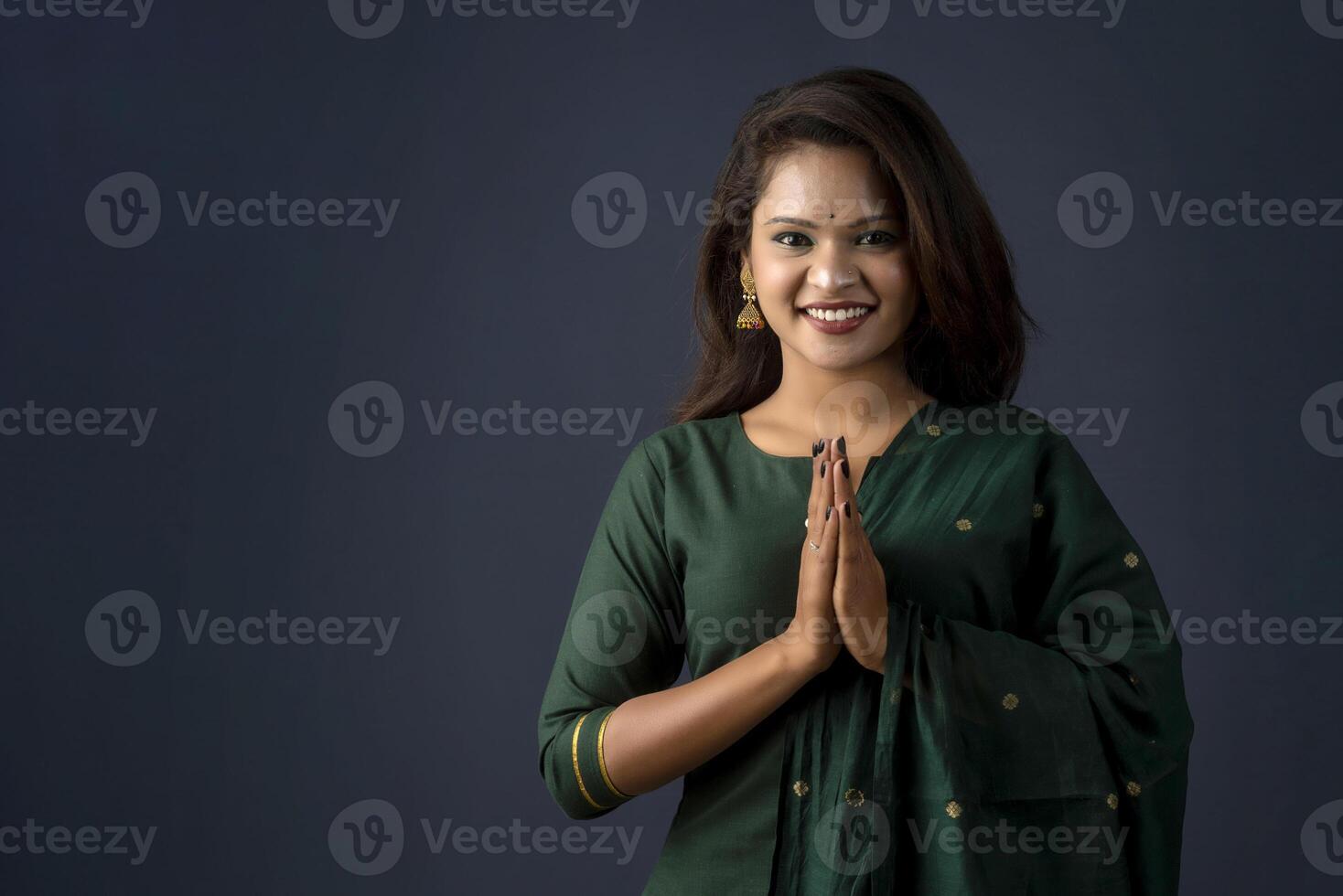 Portrait of a beautiful Indian girl in a greeting pose to Namaste hands. photo
