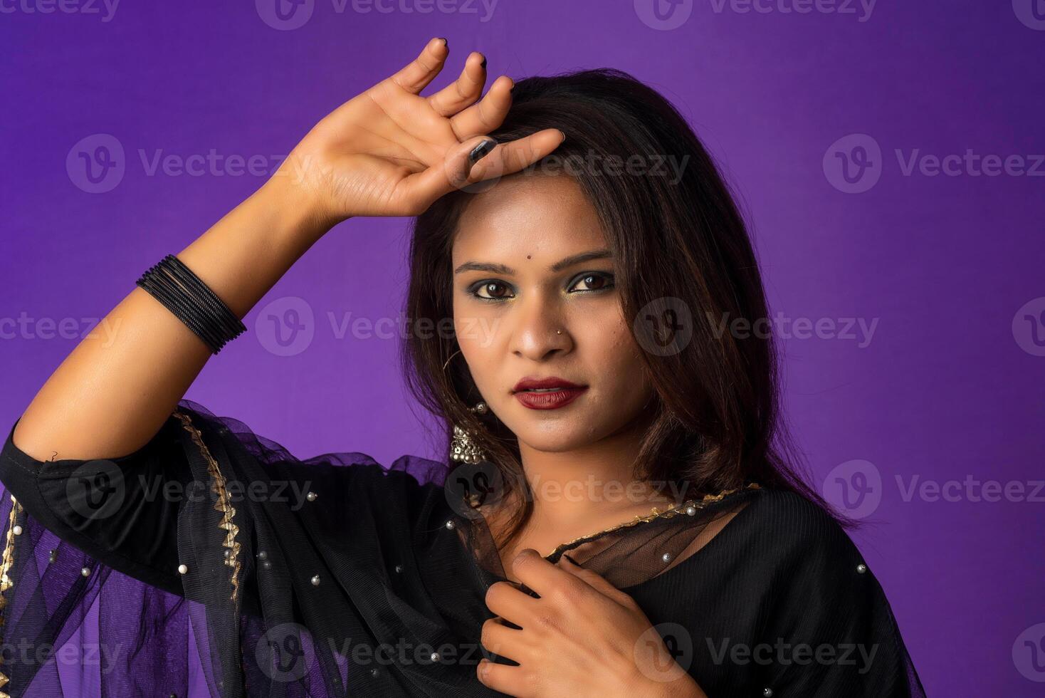 Portrait of a young girl or woman posing on purple background photo