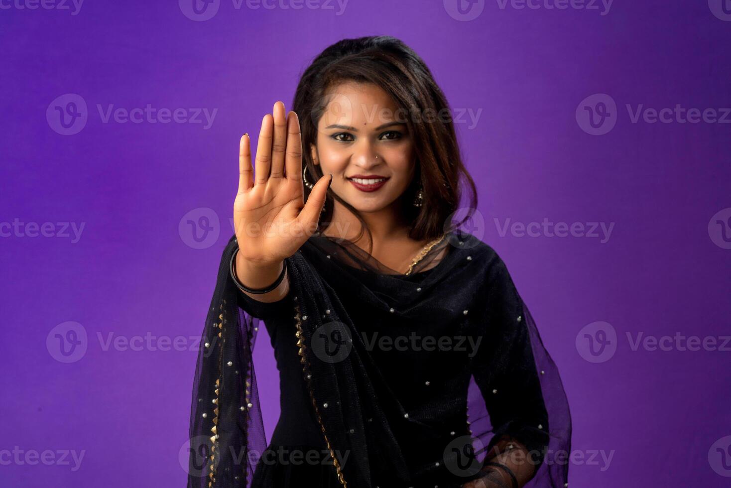 Definitely no, prohibited access Portrait of a girl crossing hands and showing palm, stop gesture, warning of end finish, forbidden way. indoor studio shot on purple background photo