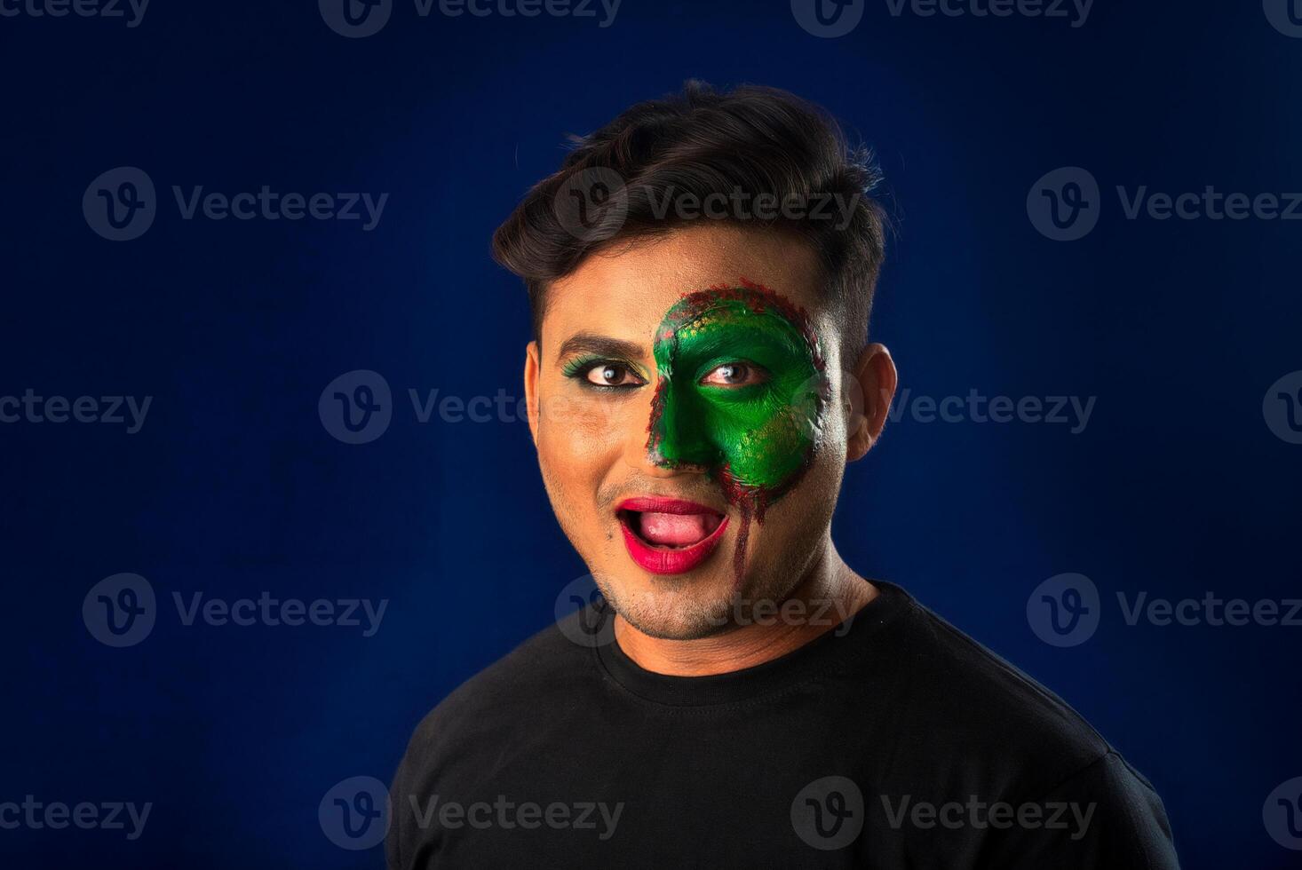 A young man with art creative makeup on his face like a snake. Half face portrait with scary zombie makeup or Halloween face art. photo