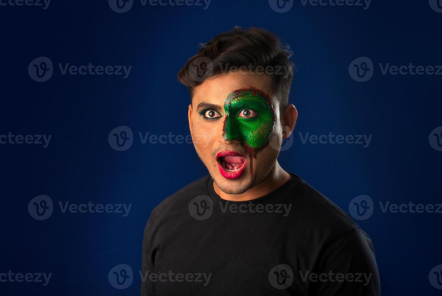 A young man with art creative makeup on his face like a snake. Half face portrait with scary zombie makeup or Halloween face art. photo