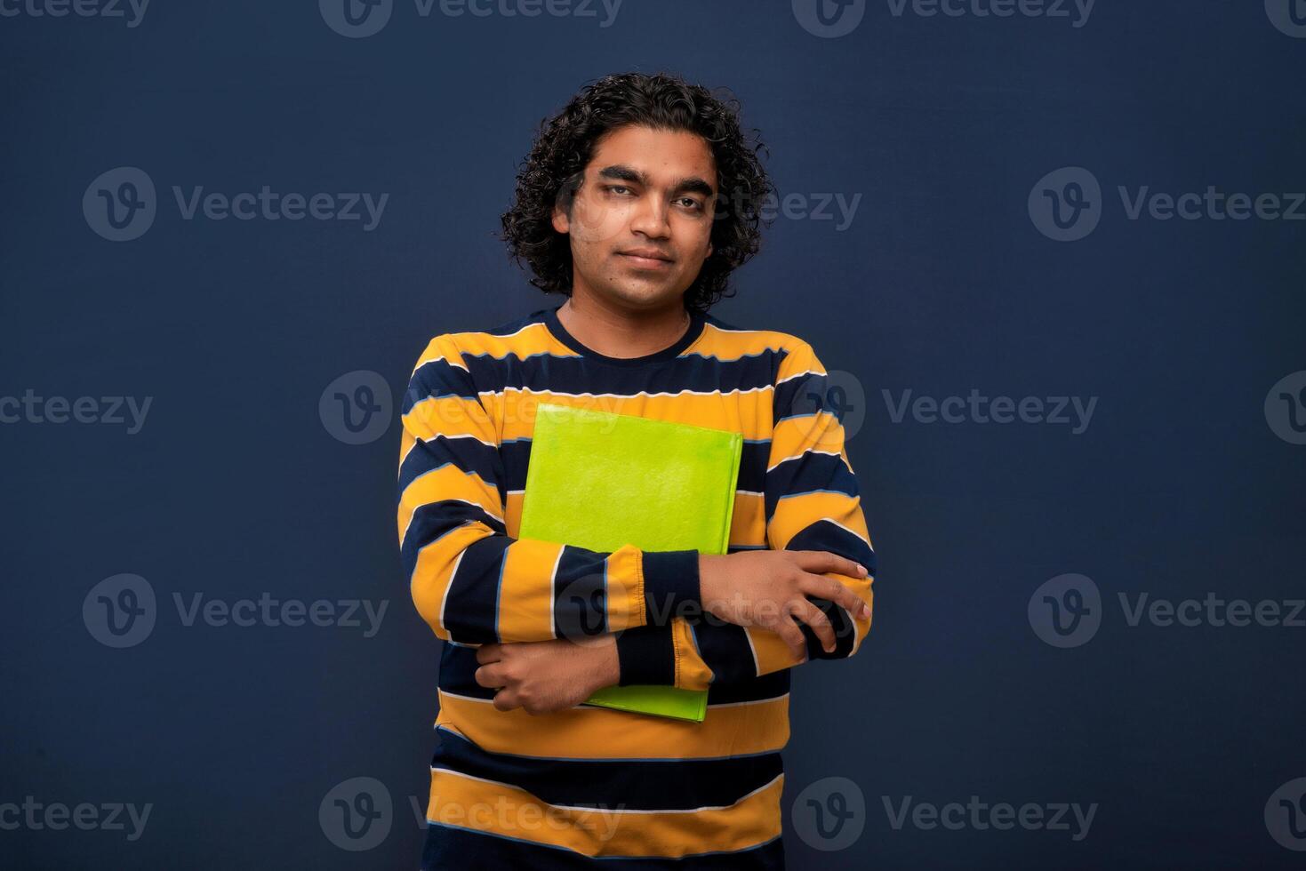 Young happy man holding and posing with the book on gray background. photo