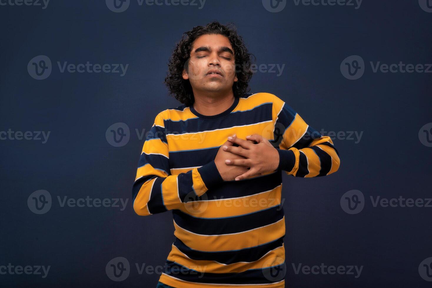 A man with long curly hair and a striped shirt photo