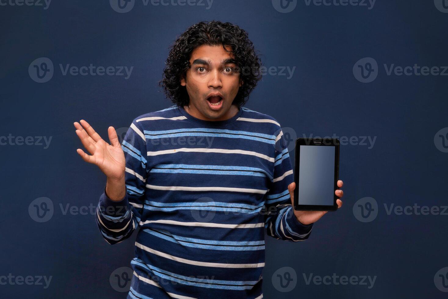 Young handsome young man, businessman showing a blank screen of smartphone or mobile or tablet phone on grey background photo