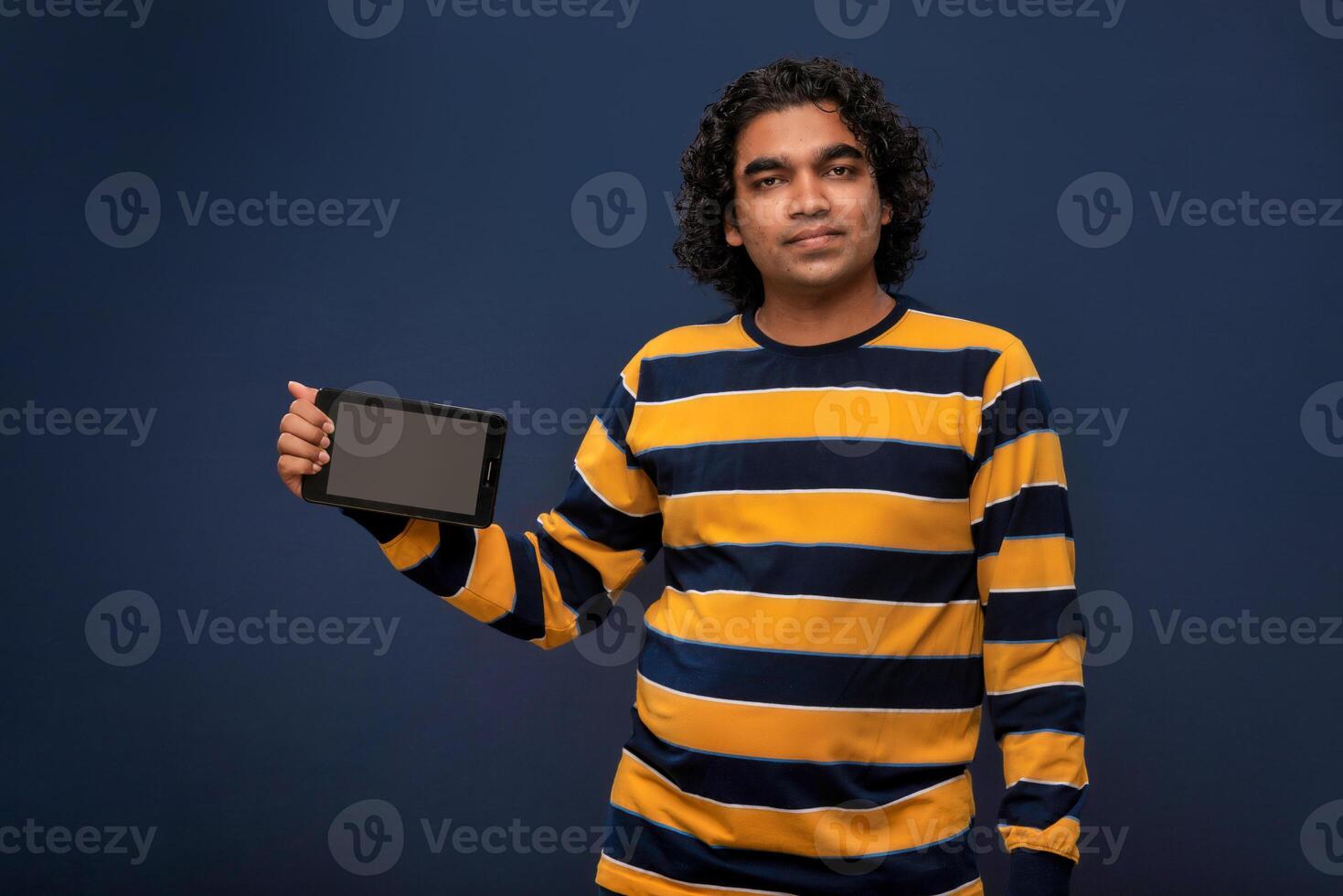 Young handsome young man, businessman showing a blank screen of smartphone or mobile or tablet phone on grey background photo