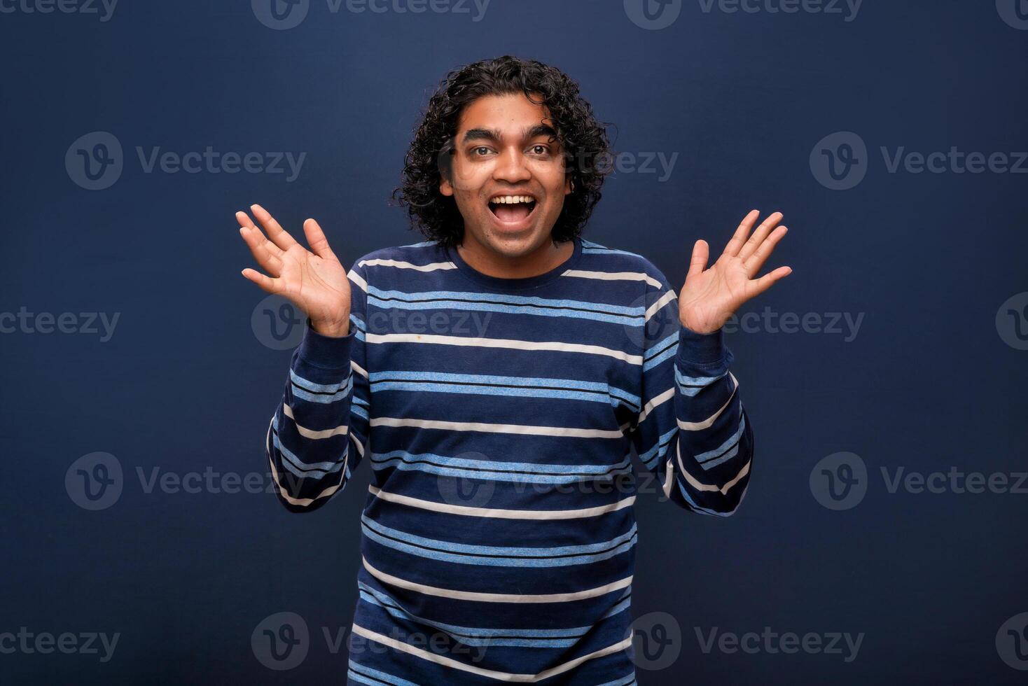 Young handsome man over gray background afraid and shocked with surprise and amazed expression, fear and excited face. photo
