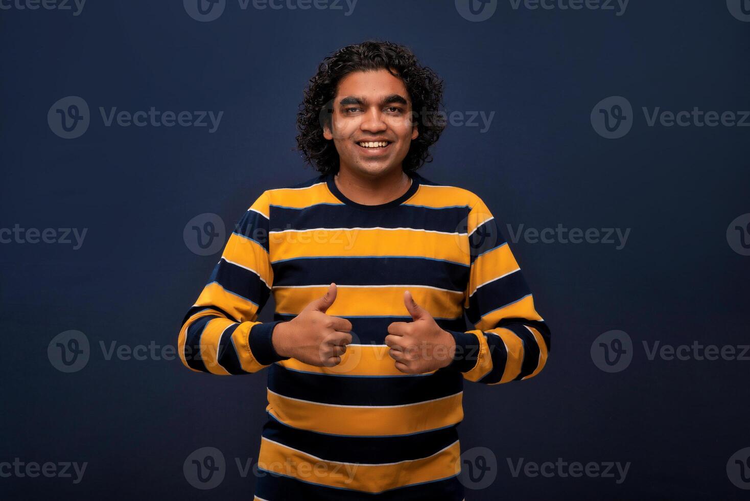 Portrait of a successful cheerful young man pointing and presenting ok, victory sign with hand or finger with a happy smiling face. photo