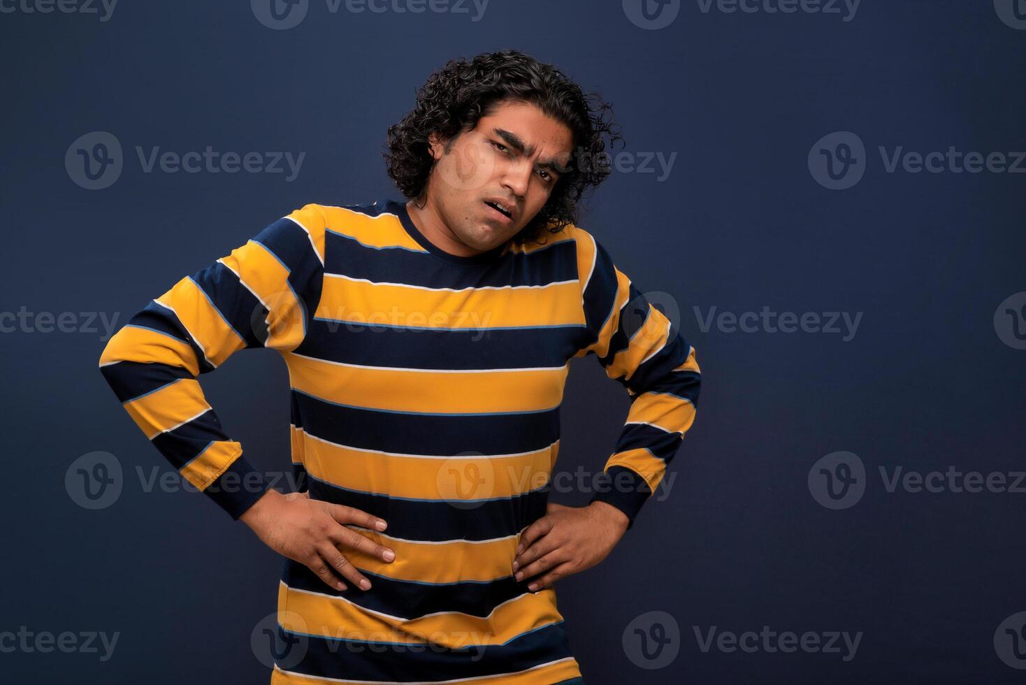 Unhappy man suffering from stomach ache over gray background. People, healthcare, and health problem concept. photo