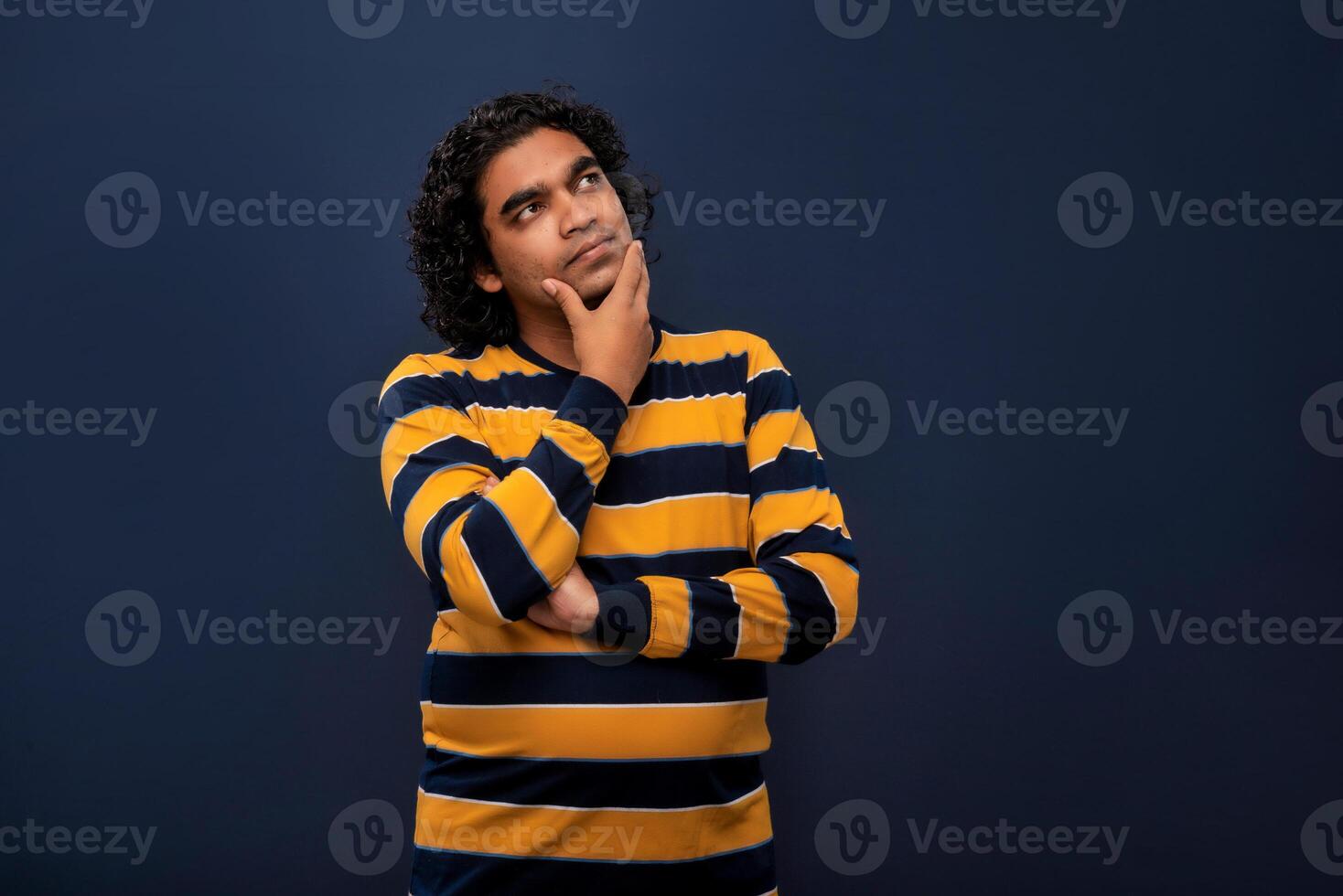 Portrait of a young man thinking on a dark background photo