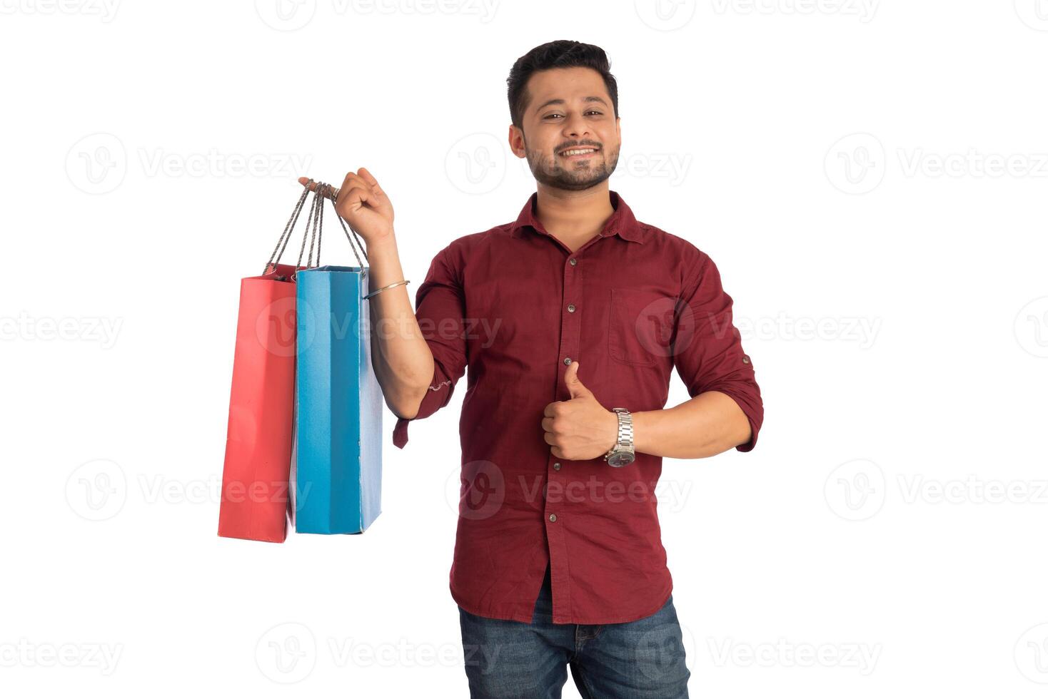 Young handsome man holding and posing with shopping bags on a white background photo