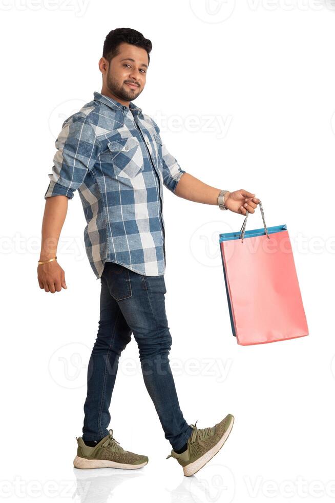 Young handsome man holding and posing with shopping bags on a white background photo