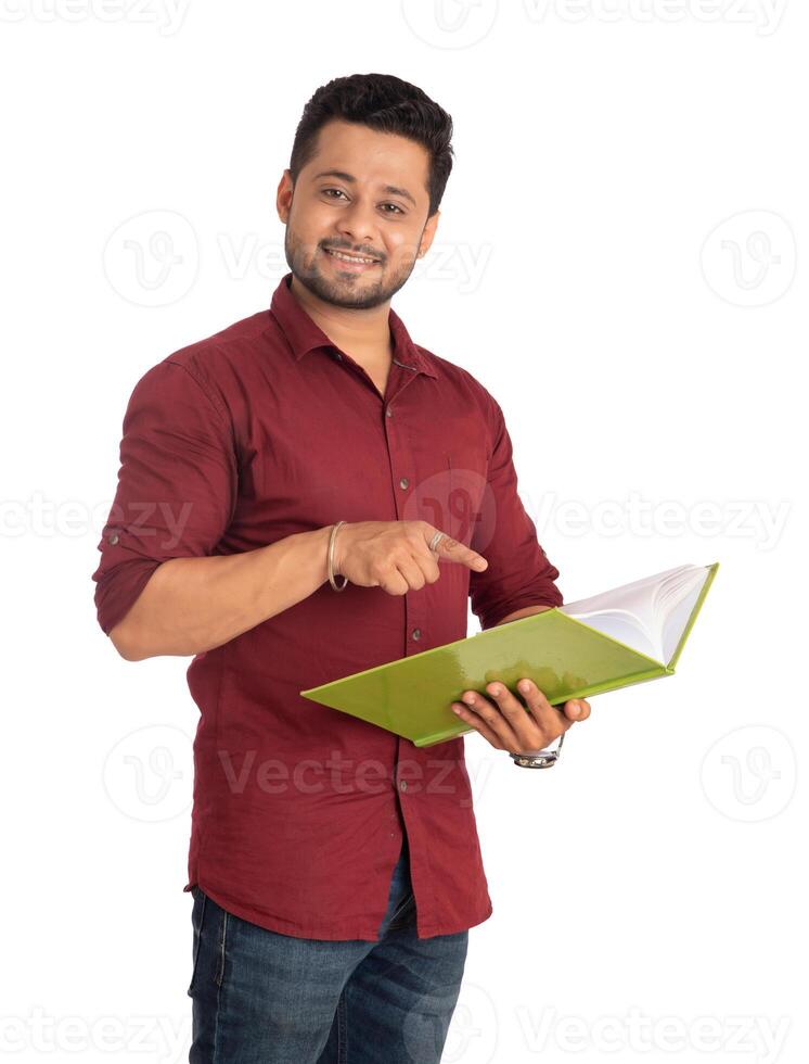 Young happy man holding and posing with the book on white background. photo
