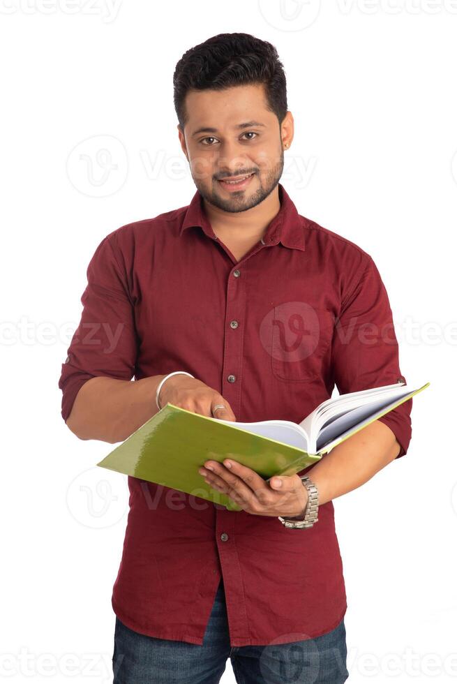 Young happy man holding and posing with the book on white background. photo