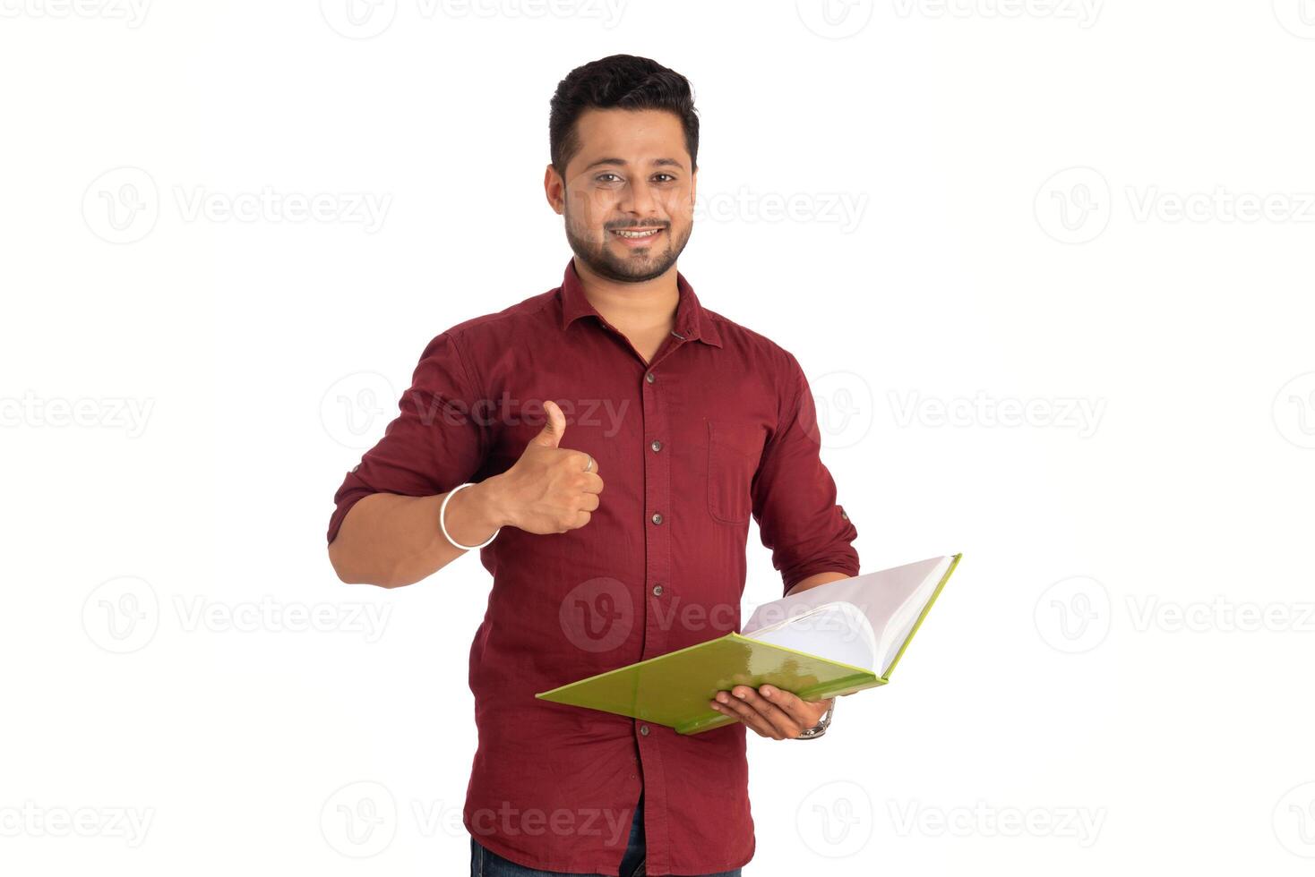 Young happy man holding and posing with the book on white background. photo