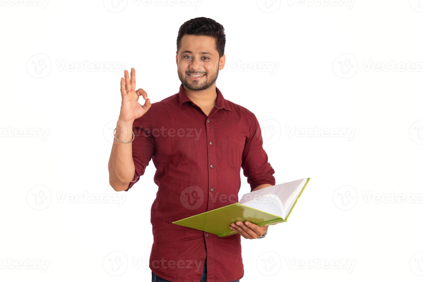 Young happy man holding and posing with the book on white background. photo