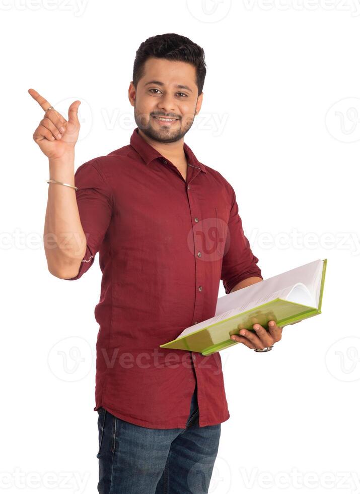 Young happy man holding and posing with the book on white background. photo