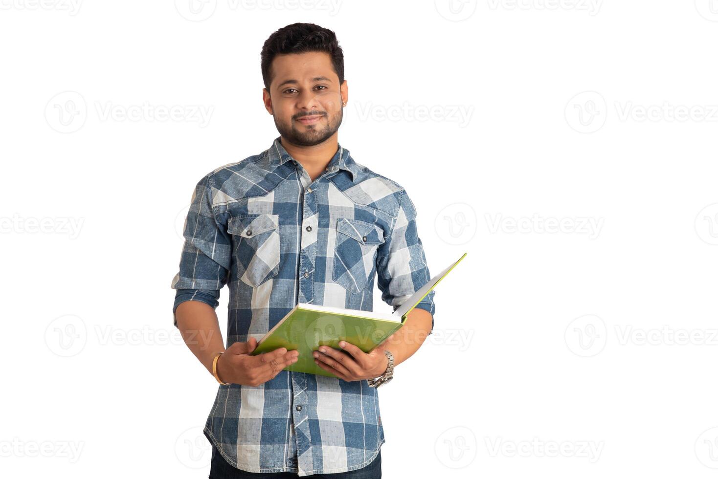 Young happy man holding and posing with the book on white background. photo