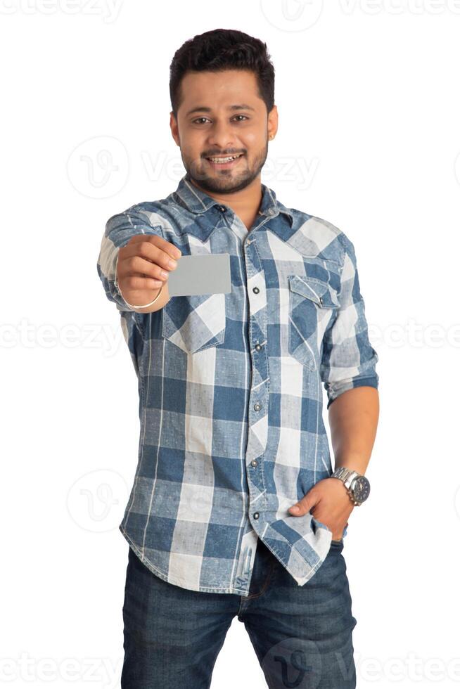 Young smiling handsome man posing with a credit or debit card on white background. photo