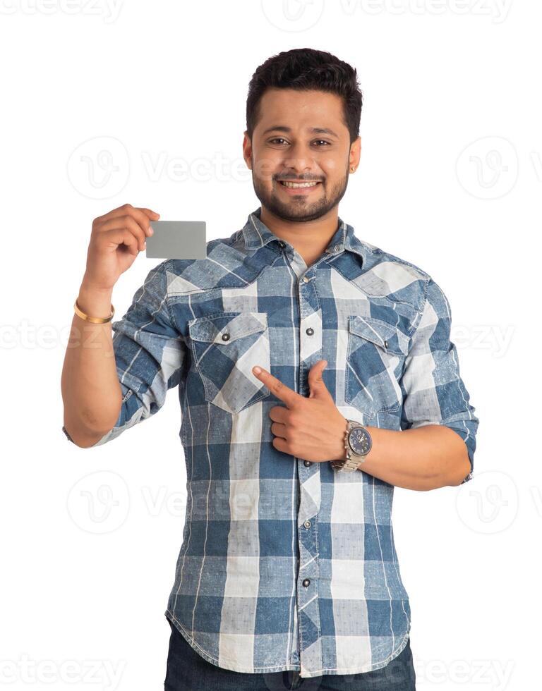 Young smiling handsome man posing with a credit or debit card on white background. photo