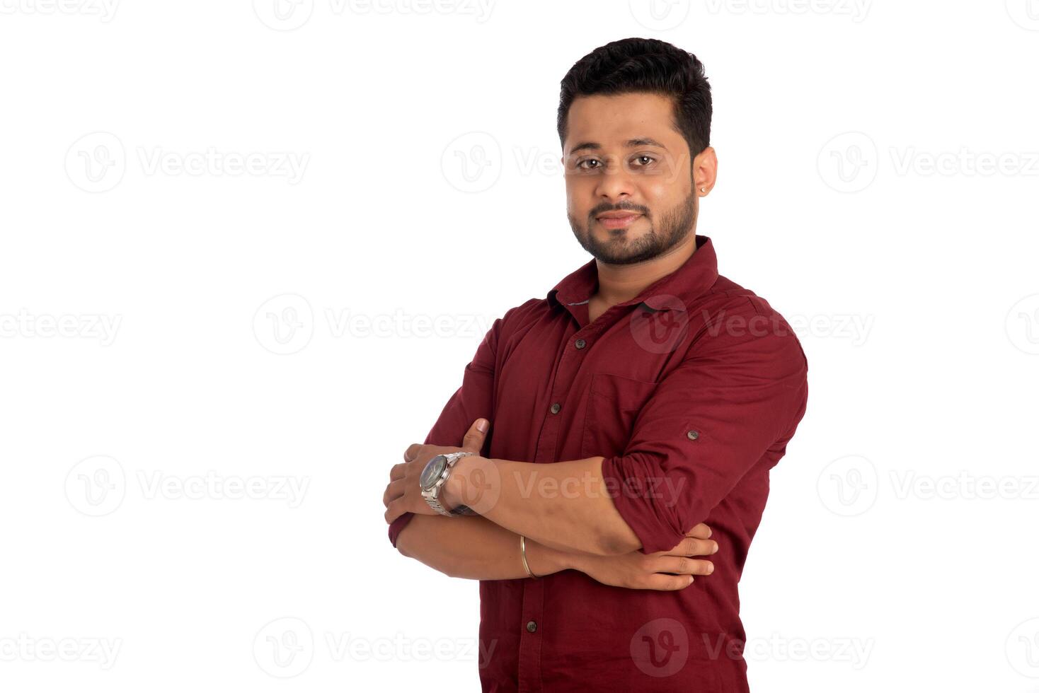 Portrait of a happy young man posing with arms crossed or hands folded on a white background photo