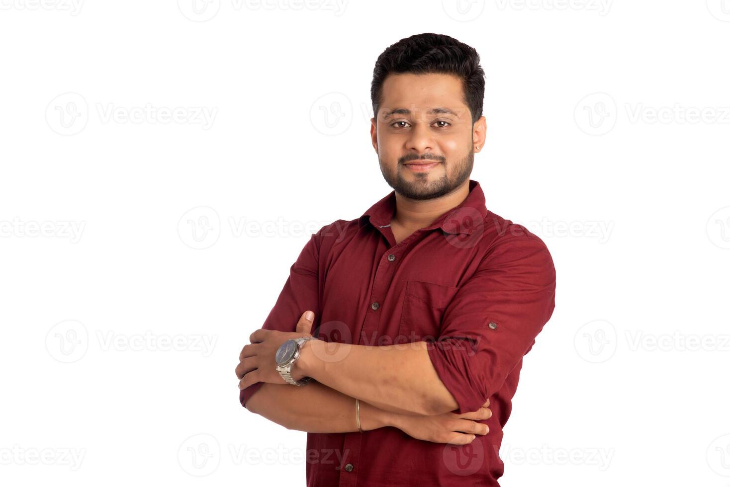 Portrait of a happy young man posing with arms crossed or hands folded on a white background photo