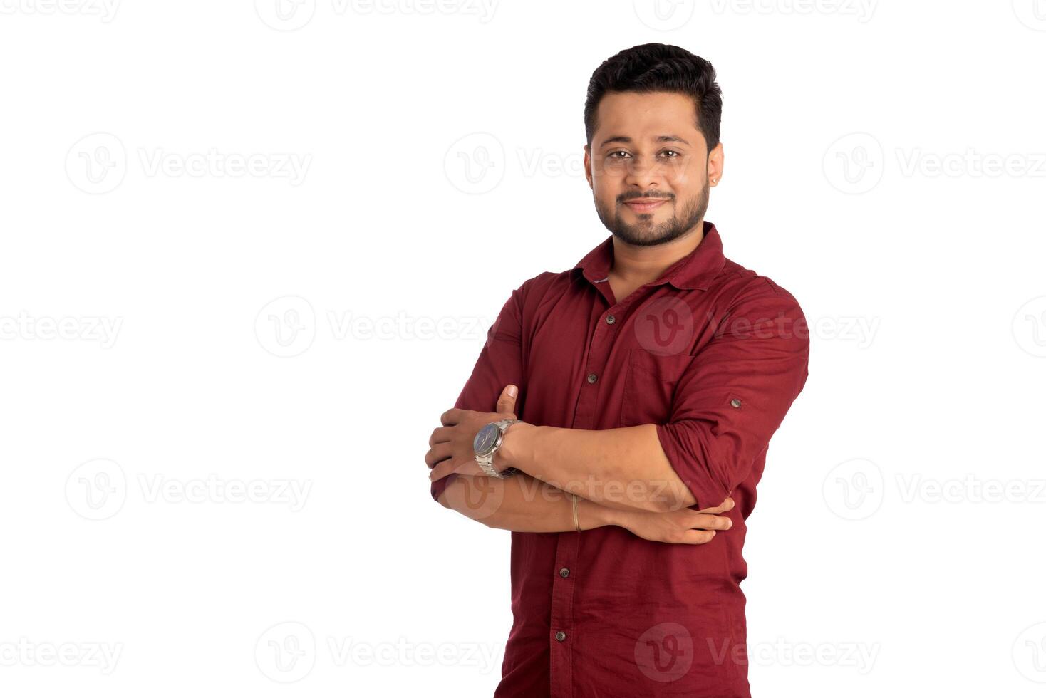 Portrait of a happy young man posing with arms crossed or hands folded on a white background photo