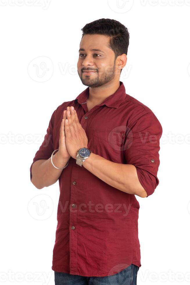 Young Indian man with welcome expression or inviting or greeting Namaste on a white background photo