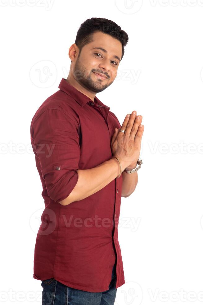 Young Indian man with welcome expression or inviting or greeting Namaste on a white background photo