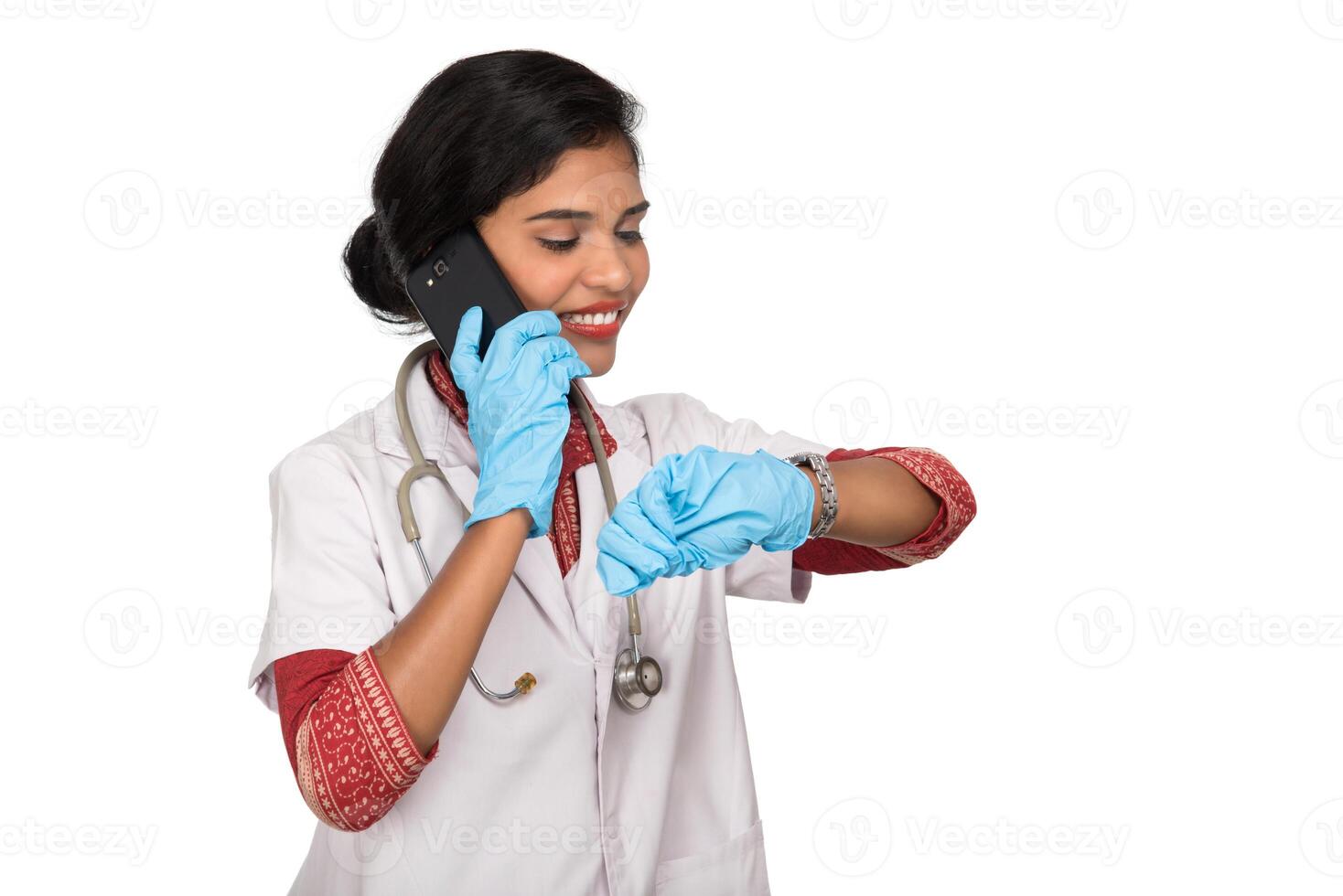 Female doctor with stethoscope talking on mobile phone on white background photo