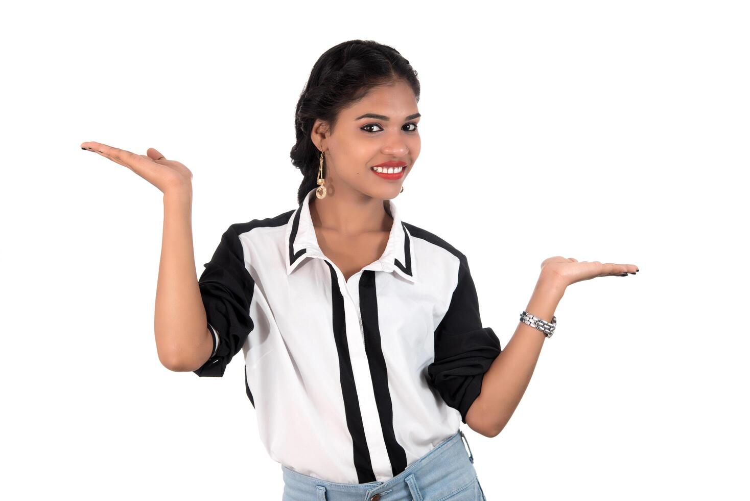 Beautiful girl holding and presenting something in the hand with happy smiling. photo