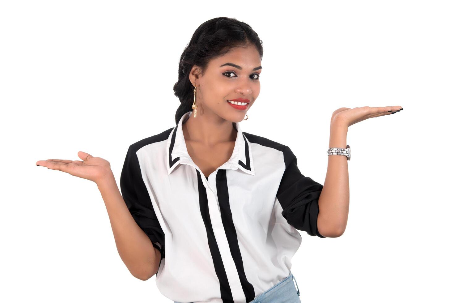 Beautiful girl holding and presenting something in the hand with happy smiling. photo